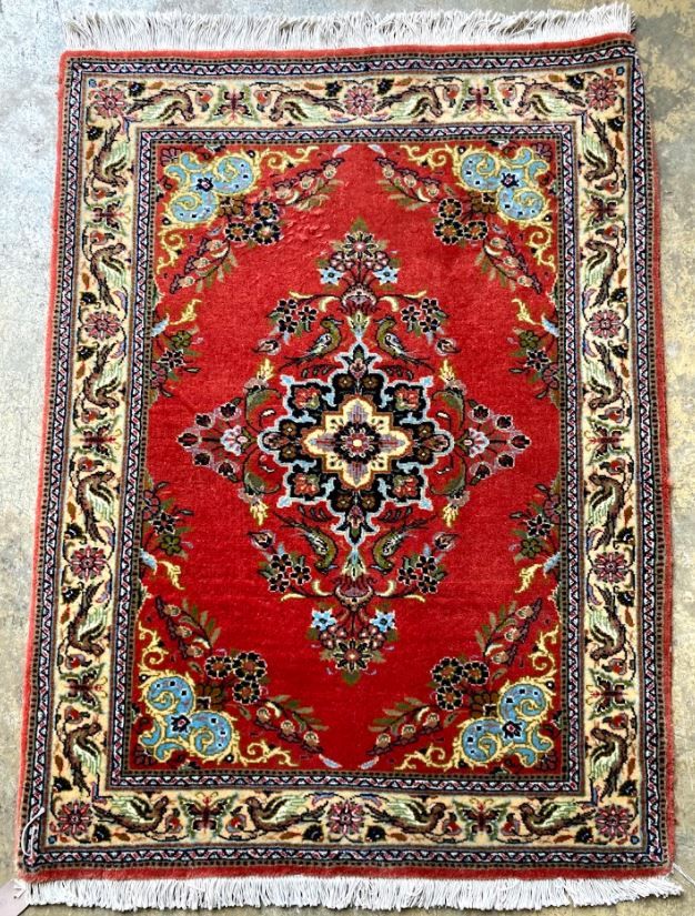 A Qum red ground rug, 100 x 74cm
